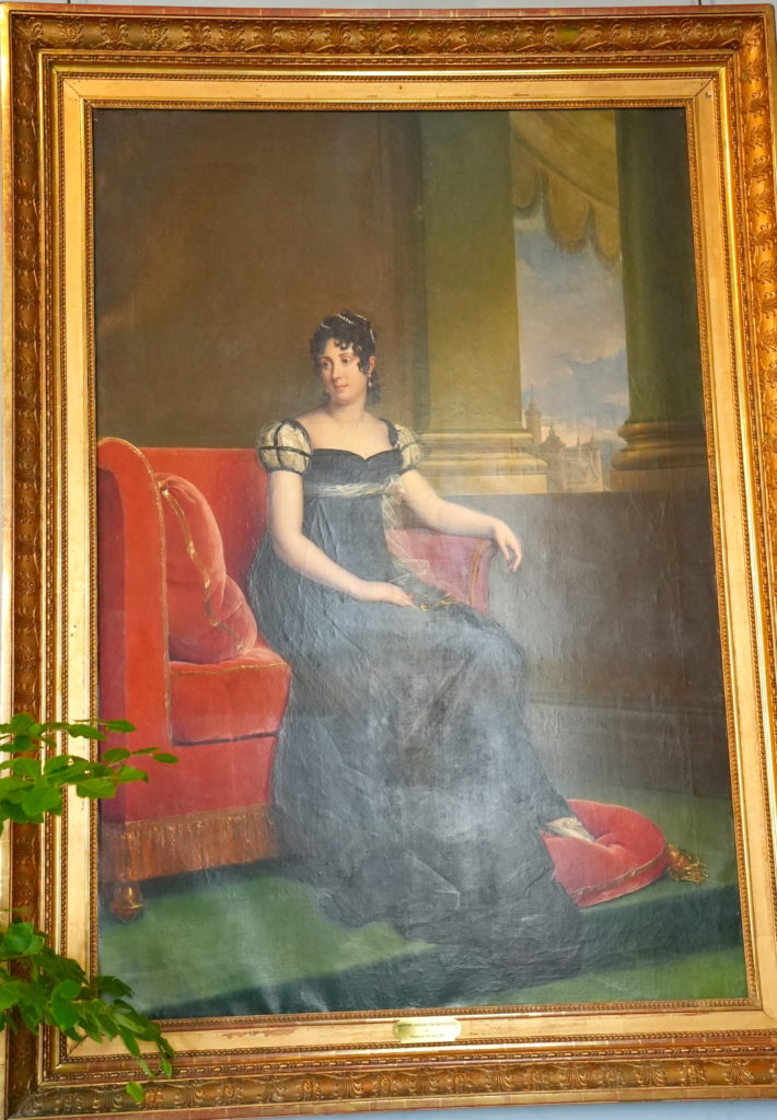 Woman sitting on very large red chair.